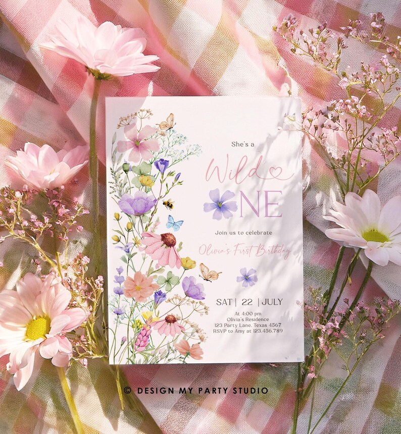 May include: A floral-themed first birthday invitation with a watercolor design featuring pink, purple, and yellow flowers. The text reads "She's a Wild One" and includes details for the party, including the date, time, and location.