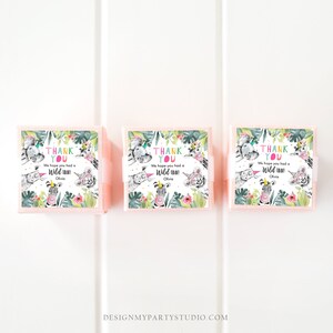 May include: Three pink favor boxes with a jungle-themed design. Each box features a watercolor illustration of various animals, including a zebra, tiger, and elephant, with the text "THANK YOU" and "We hope you had a Wild Time!" in colorful lettering.