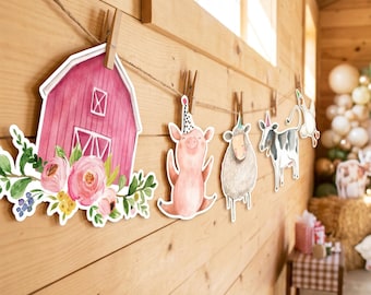 Könnte beinhalten: Eine dekorative Girlande mit Aquarell-Ausschnitten einer rosa Scheune mit Blumen, einem Schwein, einem Schaf, einer Kuh und einer Gans, die alle Partyhüte tragen. Die Papierfiguren sind mit kleinen Holzklammern an einer Schnur befestigt.