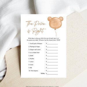 May include: A white baby shower game card with the text "The Price is Right" in elegant script. A light brown bear-shaped balloon graphic is in the upper right corner. The card lists baby items with spaces for prices.