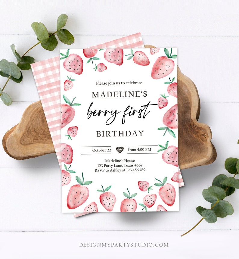 May include: A pink and white gingham patterned background with a white card featuring a watercolor illustration of strawberries. The card is a birthday invitation for Madeline's first birthday. The text on the card reads "Please join us to celebrate Madeline's berry first birthday. October 22 from 4:00 PM. Madeline's House 123 Party Lane, Texas 4567. RSVP to Ashley at 123.456.789. Designmypartystudio.com."