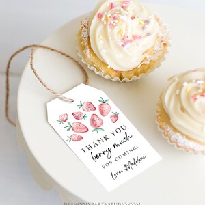 Peut inclure: Une &eacute;tiquette blanche avec des fraises &agrave; l'aquarelle et le texte "THANK YOU berry much for coming! Love, Madeline" est suspendue pr&egrave;s de deux cupcakes avec du gla&ccedil;age blanc et des vermicelles. L'&eacute;tiquette est attach&eacute;e avec de la ficelle.