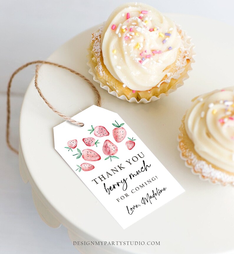 Peut inclure: Une &eacute;tiquette blanche avec des fraises &agrave; l'aquarelle et le texte "THANK YOU berry much for coming! Love, Madeline" est suspendue pr&egrave;s de deux cupcakes avec du gla&ccedil;age blanc et des vermicelles. L'&eacute;tiquette est attach&eacute;e avec de la ficelle.
