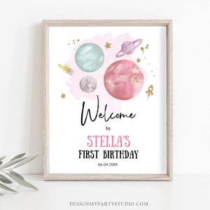 May include: A pink and blue watercolor space-themed welcome sign with planets, stars, and a rocket ship. The text reads "Welcome to Stella's First Birthday 06.04.20XX".