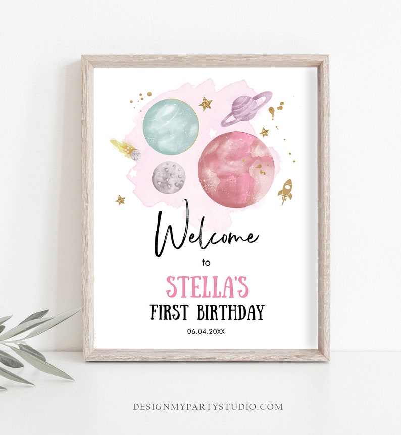 May include: A pink and blue watercolor space-themed welcome sign with planets, stars, and a rocket ship. The text reads "Welcome to Stella's First Birthday 06.04.20XX".