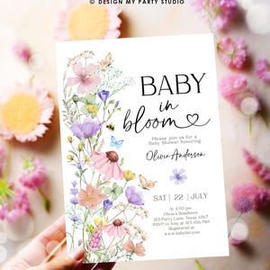 May include: A baby shower invitation with a floral design. The invitation says "Baby in Bloom" and features a watercolor illustration of pink, purple, and yellow flowers. The text also includes the date, time, and location of the shower, as well as the name of the guest of honor, Olivia Anderson.