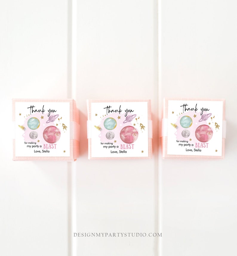 May include: Three pink boxes with thank you tags. The tags feature a watercolor illustration of planets and stars with gold glitter accents. The text on the tags reads "Thank you for making my party a BLAST Love, Stella".