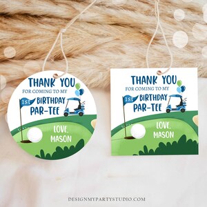 Peut inclure: Deux &eacute;tiquettes de remerciement rondes et carr&eacute;es sur le th&egrave;me du golf. Les &eacute;tiquettes sont vertes et bleues avec une voiturette de golf, une balle de golf et le texte "Merci d'&ecirc;tre venu &agrave; mon 1er anniversaire Par-Tee. Avec amour, Mason."