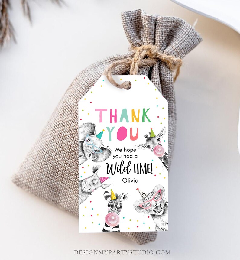 May include: Thank you favour tag with colourful letters and a white background. The tag features a cartoon illustration of a zebra, giraffe, elephant, and lion wearing party hats and holding balloons. The text reads "Thank You, We hope you had a Wild Time! Olivia".