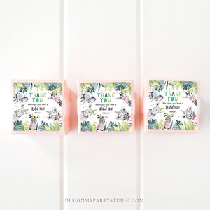 May include: Three pink favor boxes with green and white jungle animal designs. Each box has a white label with the text "Thank You" and "We hope you had a Wild Time! Mason".
