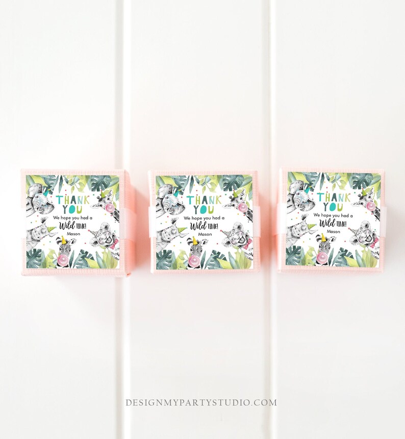 May include: Three pink favor boxes with green and white jungle animal designs. Each box has a white label with the text "Thank You" and "We hope you had a Wild Time! Mason".