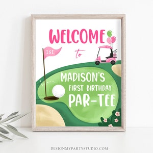 May include: A pink and green golf-themed birthday party sign with the text "Welcome to Madison's First Birthday Par-Tee".