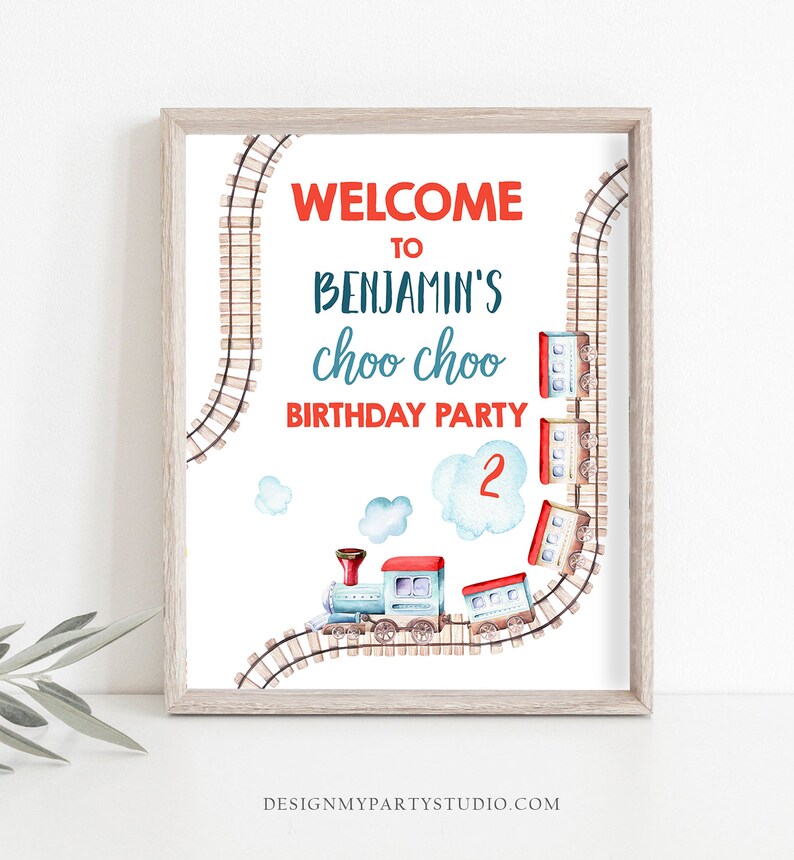 Puede incluir: Un cartel de bienvenida imprimible para una fiesta de cumplea&ntilde;os. El cartel presenta un tren azul y rojo sobre un fondo blanco. El texto en el cartel dice "Bienvenido a la fiesta de cumplea&ntilde;os de Benjamin's choo choo 2".