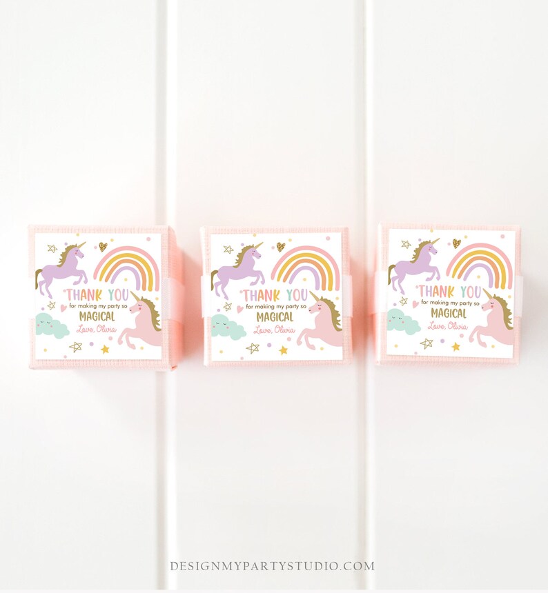 May include: Three pink favor boxes with unicorn and rainbow designs. Each box has a thank you message that reads "Thank you for making my party so magical. Love, Olivia."