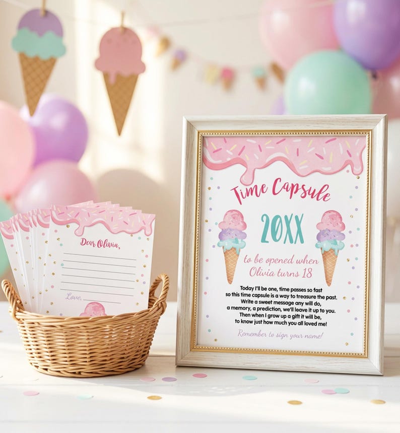 May include: A framed sign titled Time Capsule with ice cream graphics and text for Olivia, alongside a wicker basket filled with matching lined cards featuring pink icing and sprinkle designs, all set against a backdrop of colorful party balloons.