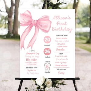 Könnte beinhalten: Ein rosa-weißes, druckbares Schild für den ersten Geburtstag mit einer großen rosa Schleife oben. Das Schild enthält den Namen "Allison's First Birthday" und Details über das Alter, das Gewicht, die Größe, die Lieblingsessen und die Aktivitäten des Kindes.