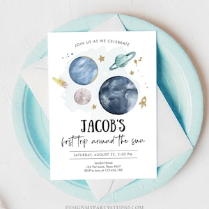 May include: A blue and white invitation with a watercolor illustration of planets and stars. The text reads "JOIN US AS WE CELEBRATE JACOB'S first trip around the sun SATURDAY, AUGUST 22, 2:00 PM Jacob's House 123 Part Lane, Texas 4567 RSVP to Amy at 123.456.789 DESIGNMYPARTYSTUDIO.COM"