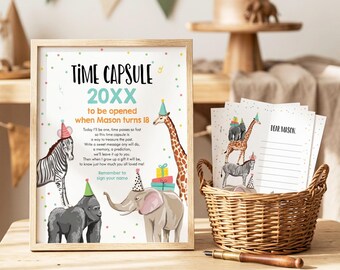 May include: A framed sign titled Time Capsule 20XX with illustrations of a zebra, gorilla, elephant, and giraffe wearing party hats, alongside a wicker basket containing matching cards with the text Dear Mason and a wooden pen on the table.