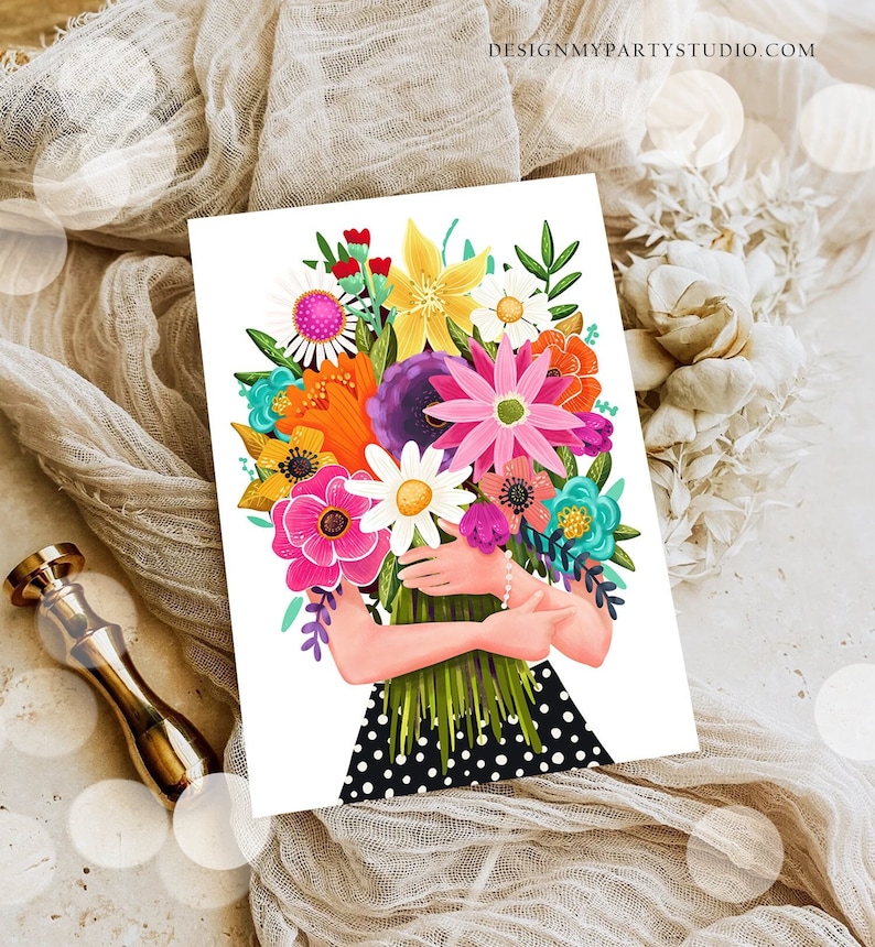 Op de afbeelding: Een kleurrijk boeket bloemen in tinten roze, paars, oranje, geel en wit, vastgehouden door een persoon die een zwart-wit gebloemde jurk draagt.