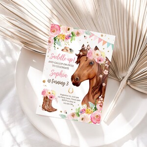 Puede incluir: Una invitaci&oacute;n de cumplea&ntilde;os rosa y blanca con un caballo marr&oacute;n que lleva una corona de flores. La invitaci&oacute;n dice "Saddle up! And gallop on over to celebrate Sophia is turning 3".