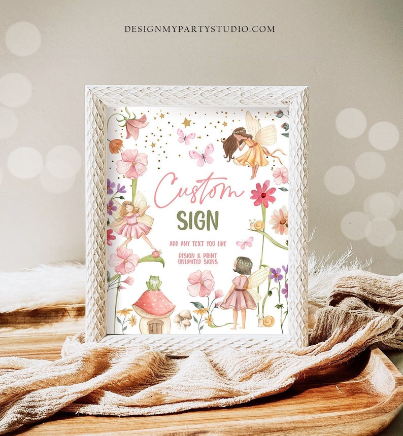 May include: A white frame with a printable sign featuring a whimsical fairy garden scene with pink flowers, butterflies, and fairies. The sign says "Custom Sign" and "Add any text you like. Design & Print Unlimited Signs".