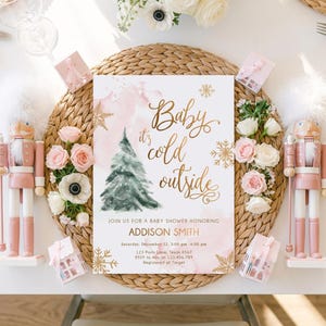 May include: A rectangular baby shower invitation card featuring a watercolour green Christmas tree, gold foil snowflakes, and the text Baby it's cold outside. The card includes details for Addison Smith on Saturday, December 22, at 123 Party Lane.