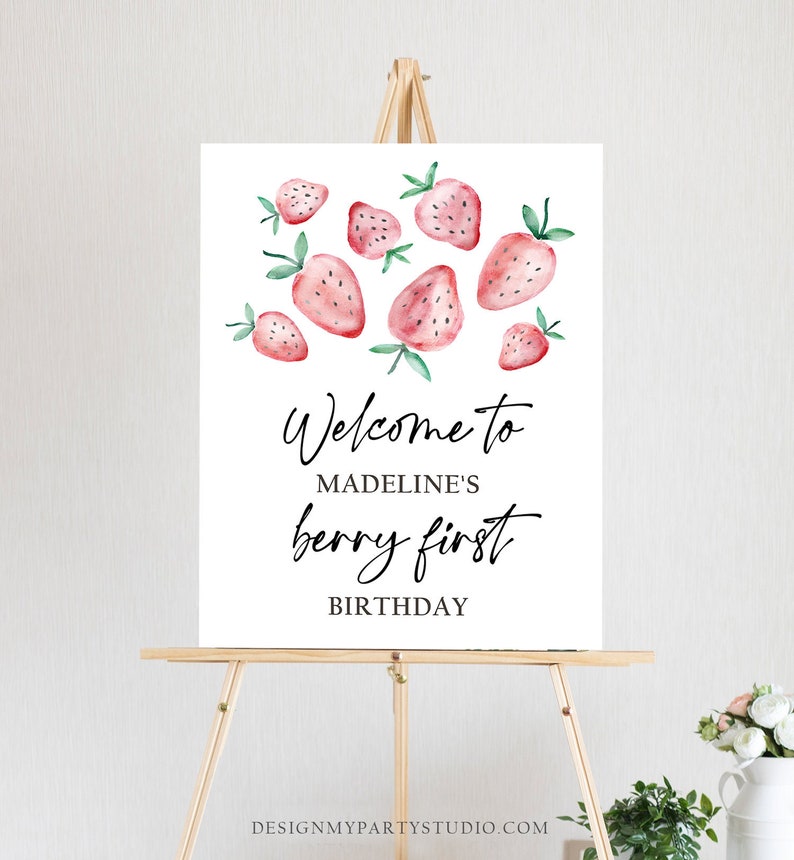 May include: Welcome to Madeline's Berry First Birthday sign with a white background and watercolor illustrations of strawberries.