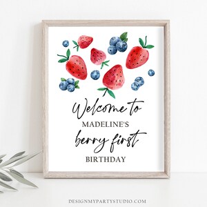 May include: Welcome to Madeline's berry first birthday sign with watercolor illustrations of strawberries and blueberries.