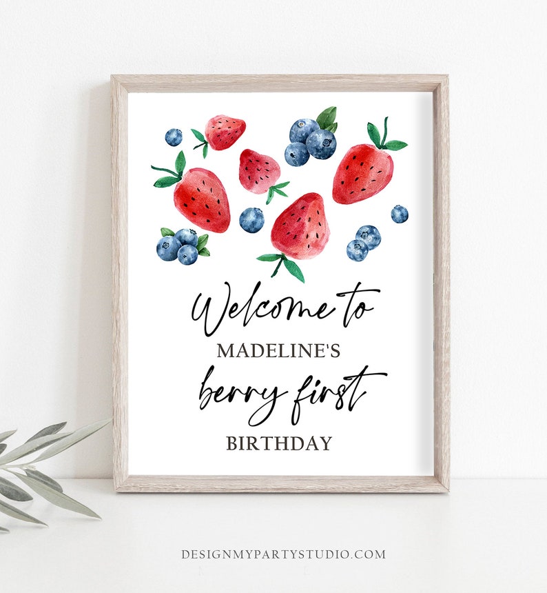 May include: Welcome to Madeline's berry first birthday sign with watercolor illustrations of strawberries and blueberries.