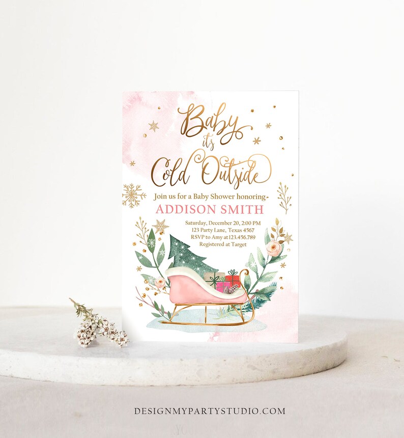 May include: A baby shower invitation with a pink and gold design. The text "Baby it's Cold Outside" is in gold script. A pink sleigh with gifts and a Christmas tree is featured. The invitation includes the name Addison Smith and event details.