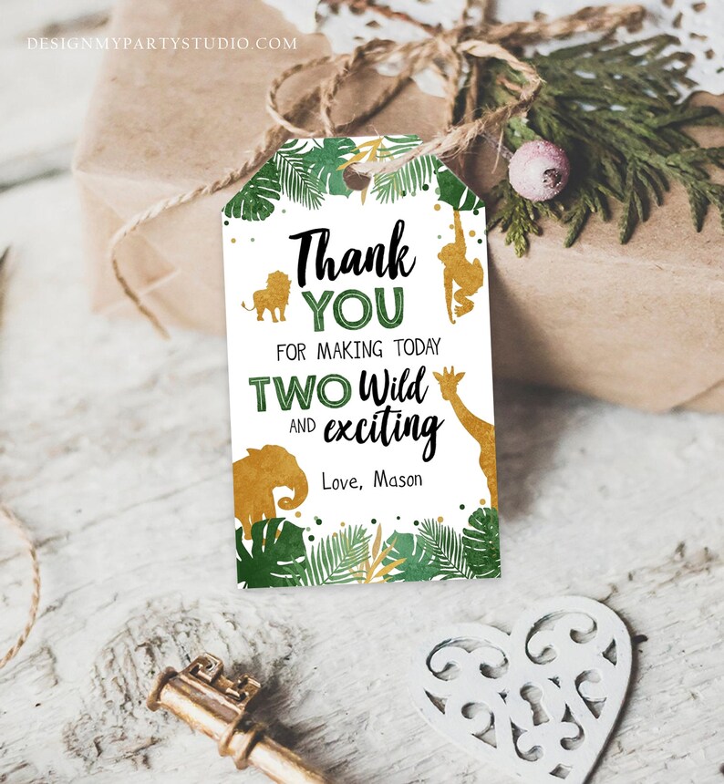 May include: A jungle-themed gift tag with the text "Thank You for making today Two Wild and exciting". The tag features gold animal silhouettes and green foliage. The tag is attached to a wrapped gift.