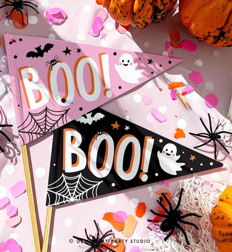 May include: Two Halloween pennant flags, one pink and one black, with the word "BOO!" in large white letters. The pink flag has a spider web, bat, spider, ghost, and stars. The black flag has a spider web, bat, spider, ghost, and stars.