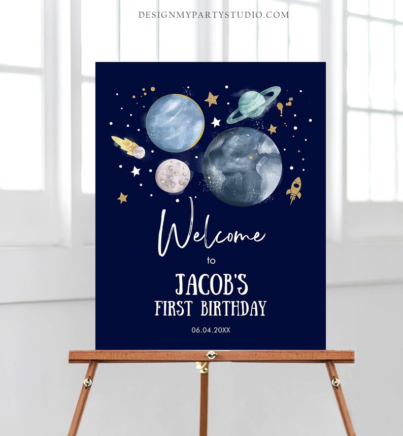 May include: A blue and gold welcome sign with a space theme. It says "Welcome to Jacob's First Birthday 06.04.20XX". The sign features planets, stars, and a rocket.