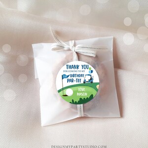 Peut inclure: Un autocollant rond vert et bleu avec une voiturette de golf, une balle de golf et un drapeau. L'autocollant dit "Merci d'&ecirc;tre venu &agrave; mon 1er anniversaire Par-Tee. Avec amour, Mason".