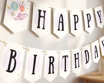 May include: A two-tier banner spelling HAPPY BIRTHDAY on white cardstock pennants with black lettering. The first pennant features watercolor planets and stars. Each letter is centered over a light purple watercolor wash with small gold stars.