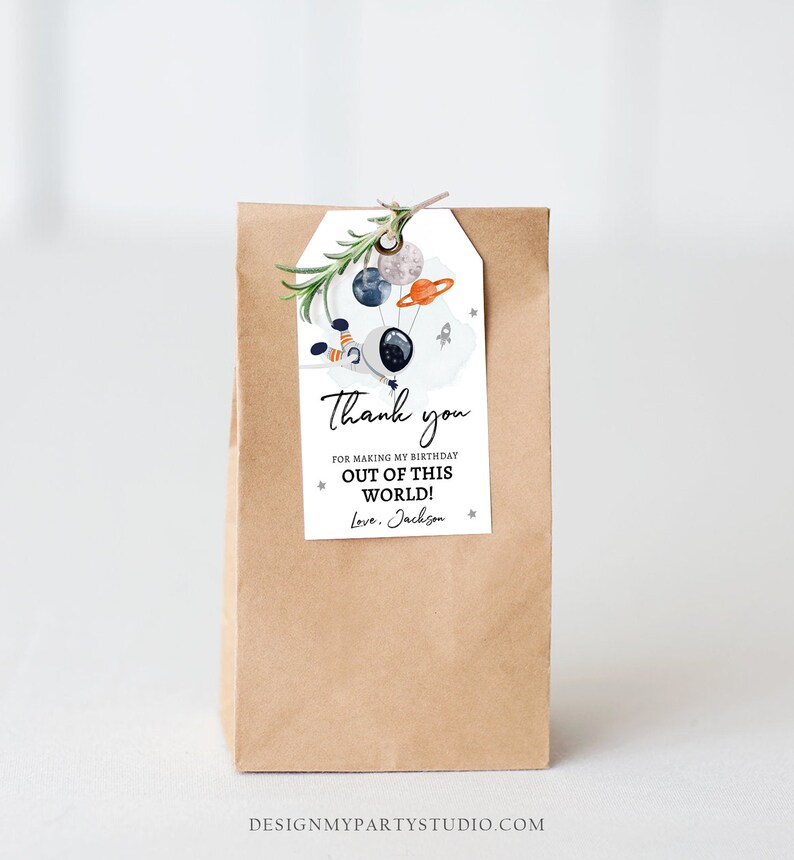 May include: A brown paper bag with a thank you tag attached. The tag features a cartoon astronaut holding balloons shaped like planets and stars. The text on the tag reads "Thank you for making my birthday out of this world! Love, Jackson."