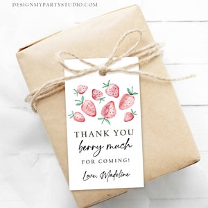Peut inclure: Un cadeau emball&eacute; dans du papier brun, orn&eacute; d'un n&oelig;ud en ficelle. Une &eacute;tiquette blanche pr&eacute;sente des fraises &agrave; l'aquarelle et le texte "THANK YOU berry much FOR COMING! Love, Madeline."