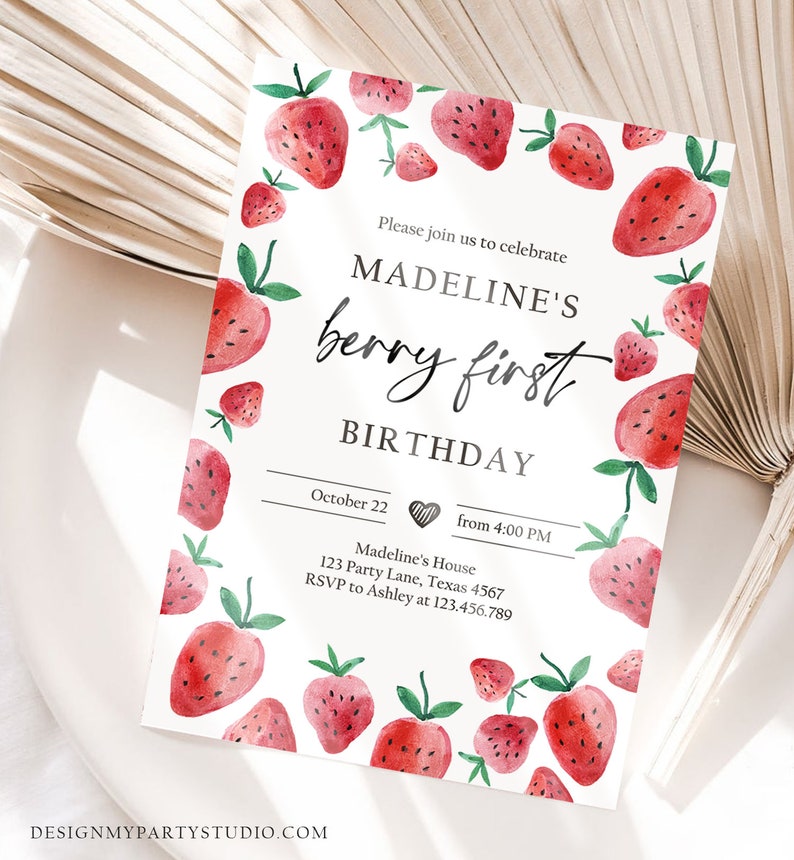 May include: A white invitation card with a watercolor illustration of red strawberries. The text reads "Please join us to celebrate Madeline's berry first birthday. October 22 from 4:00 PM. Madeline's House 123 Party Lane, Texas 4567. RSVP to Ashley at 123.456.789."