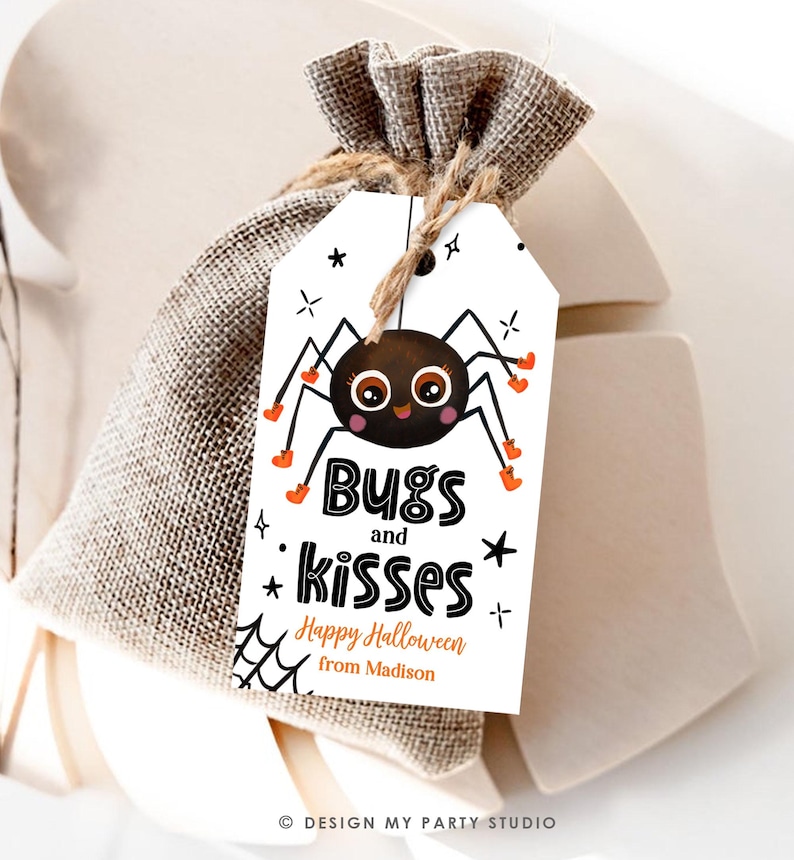 Pu&ograve; includere: Un'etichetta regalo rettangolare bianca legata con uno spago a un sacchetto di iuta. L'etichetta presenta un ragno disegnato con stivali arancioni, il testo Bugs and kisses e la scritta Happy Halloween from Madison.