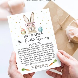 May include: A light blue and green Easter bunny with pink glasses and a carrot in its mouth. The bunny is holding a note that says "From the desk of the Easter Bunny. Dear Olivia, Hip, hop, hooray! Easter has arrived! I am so excited that it's finally here. I have so many Easter eggs and chocolate candies to fill Easter baskets with - and I am thrilled to be here delivering your goodies this year. You have been such a great big sister and I am so very proud of you! Keep up the great work at school, too. You are doing so well with following directions, being nice to your friends, and working so very hard. I have hidden 24 beautifully dyed Easter eggs for you, so have fun finding them. The Easter Bunny."