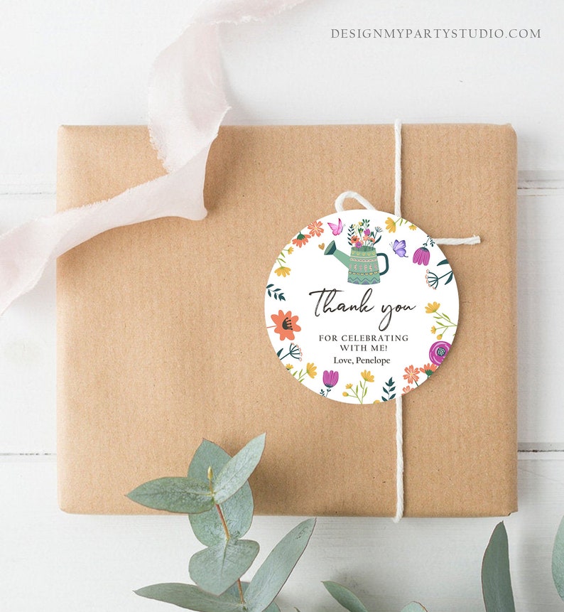 May include: Round thank you tag with a floral design. A green watering can with flowers is in the center. The text reads "Thank you for celebrating with me! Love, Penelope".