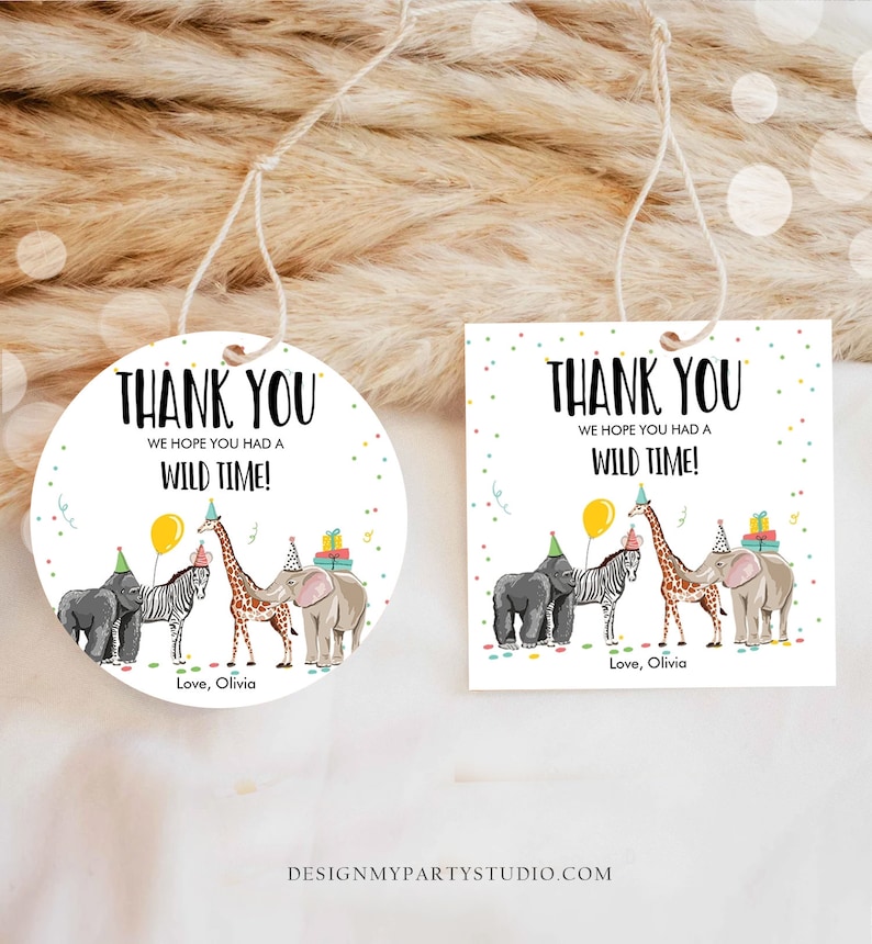 May include: Two thank you tags with a safari animal theme. The tags feature a giraffe, zebra, elephant, and gorilla wearing party hats. The text on the tags reads "Thank You We hope you had a wild time! Love, Olivia".