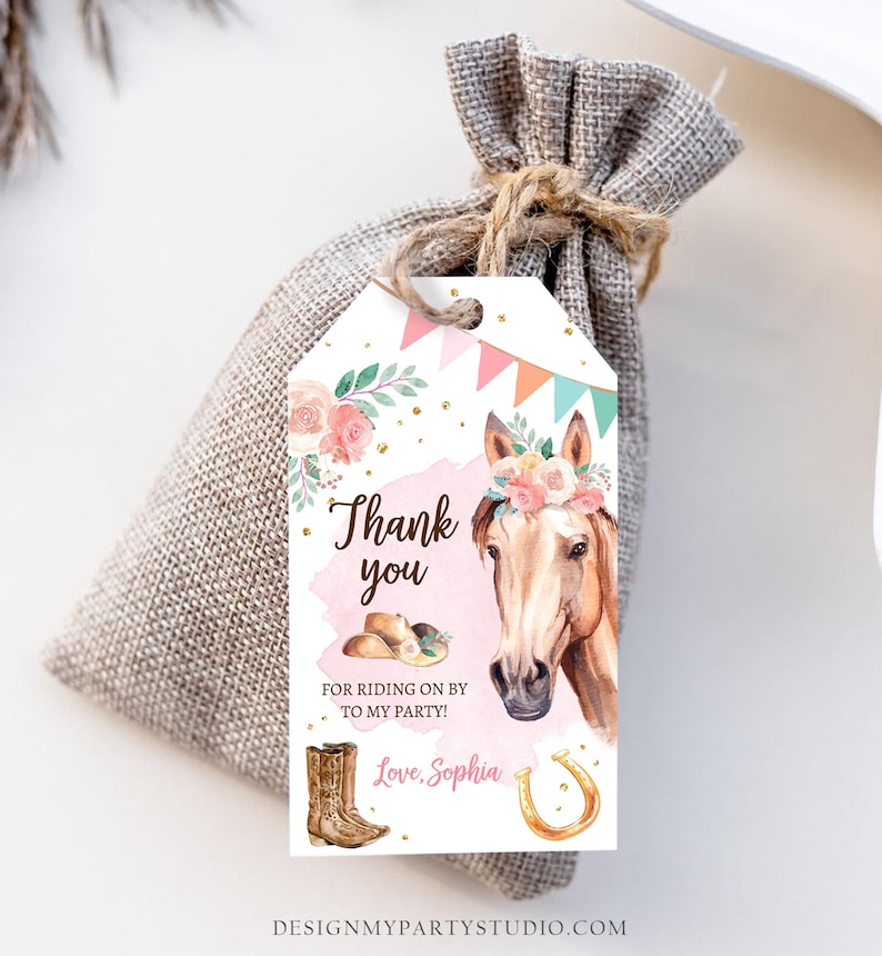 May include: Thank you for riding on by to my party!  A white tag with a pink and brown horse illustration, a pink floral crown, and gold glitter. The text "Thank you" is in brown, and the text "Love, Sophia" is in pink.  There are also brown cowboy boots and a gold horseshoe.