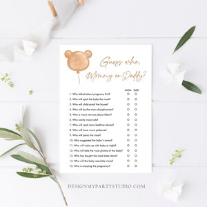 May include: A printable game card with a brown bear balloon illustration and the text "Guess who, Mommy or Daddy?"  The game features 15 questions about pregnancy and parenting, with checkboxes for "Mom" and "Dad" for each question.