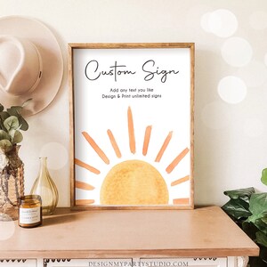 May include: A framed sign with a watercolor illustration of a sun with orange and yellow rays. The sign says "Custom Sign" and "Add any text you like Design & Print unlimited signs".