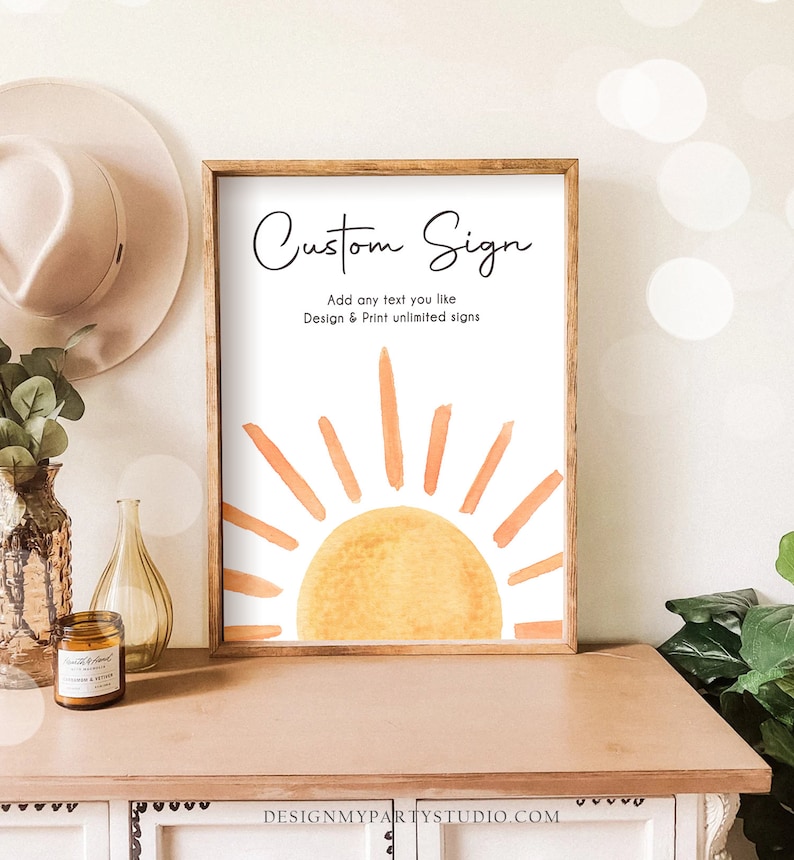 May include: A framed sign with a watercolor illustration of a sun with orange and yellow rays. The sign says "Custom Sign" and "Add any text you like Design & Print unlimited signs".