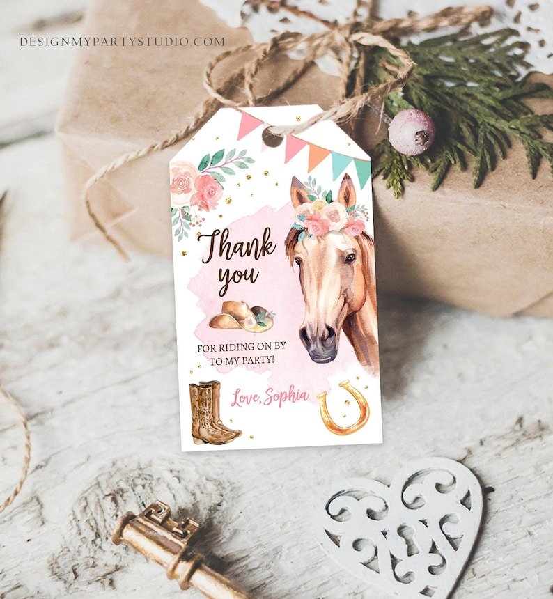 May include: A white thank you tag with a pink background and gold glitter. It features a watercolor illustration of a brown horse with a floral crown, cowboy boots, a cowboy hat, and a horseshoe. The text reads "Thank you for riding on by to my party! Love, Sophia".