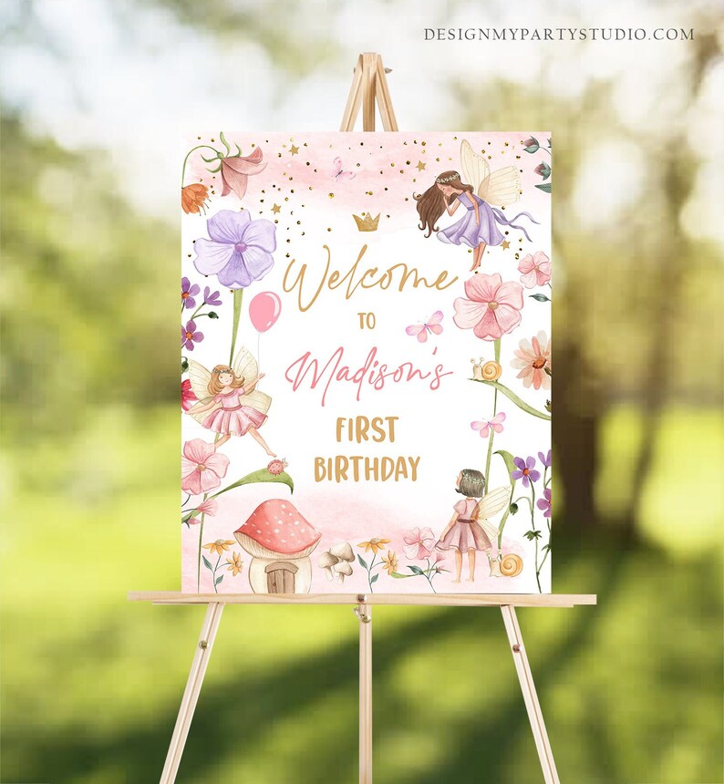 May include: Welcome to Madison's First Birthday sign with a pink and white background featuring fairies, flowers, and a mushroom house. The sign has a gold crown and gold lettering.