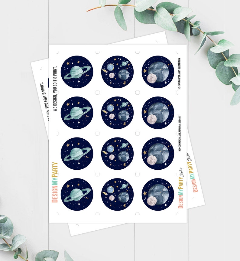May include: A sheet of printable stickers featuring a space theme. The stickers are round and feature a dark blue background with gold stars, a blue planet with rings, and a white moon. The text "DESIGNMYPARTY" is printed on the sheet.