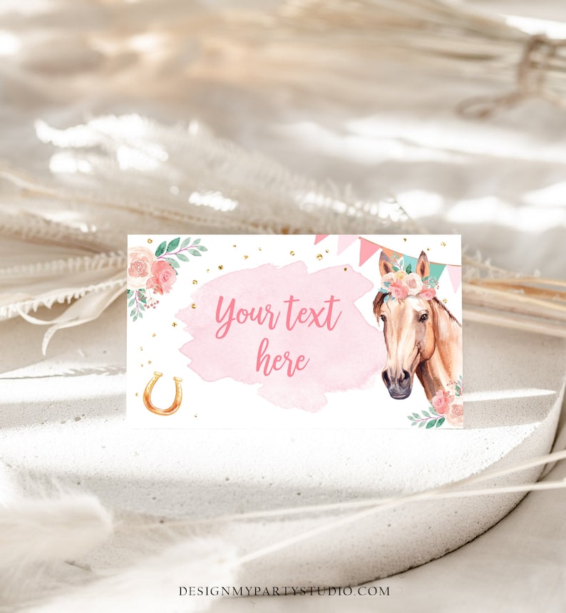K&ouml;nnte beinhalten: Rosa-wei&szlig;er druckbarer Geschenkanh&auml;nger mit Aquarellhintergrund, einem goldenen Hufeisen und einem Cartoon-Pferd mit Blumenkrone. Der Text "Your text here" steht auf dem Anh&auml;nger.